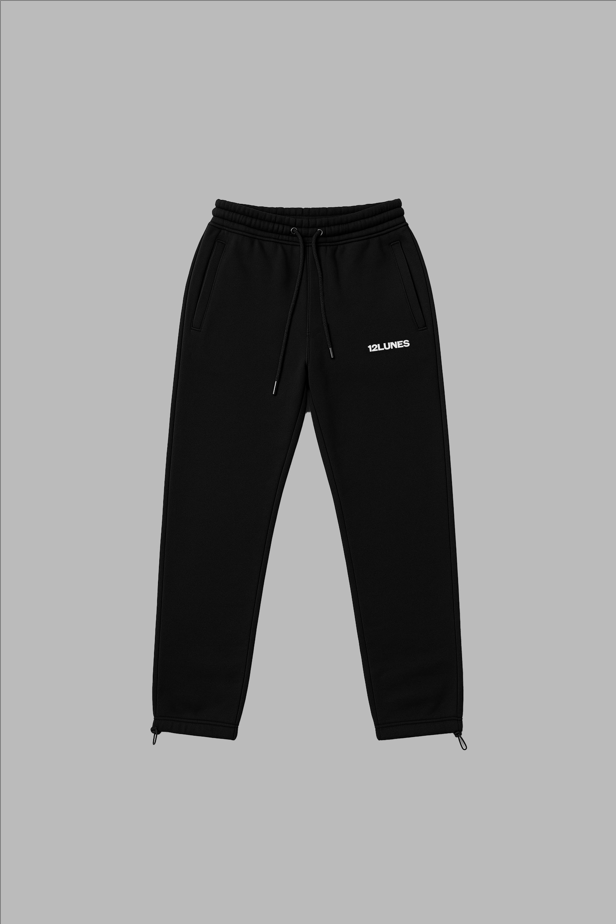 Trackpant Noir - Confort Minimaliste en coton unisexe, coupe droite avec broderie blanche 12LUNES sur la cuisse gauche. Pantalon streetwear idéal pour un look décontracté.